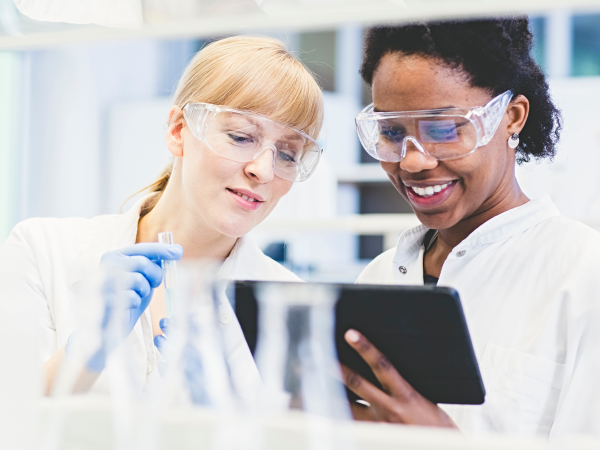 Two female scientists looking at a tablet