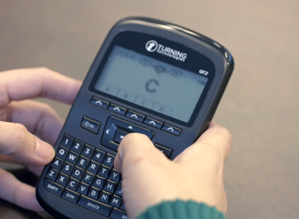 Hands holding a Turning Technologies QT2 clicker