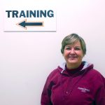 Mary Kinnear standing in front of training sign