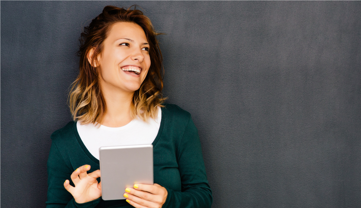 Young woman smiling and holding a tablet