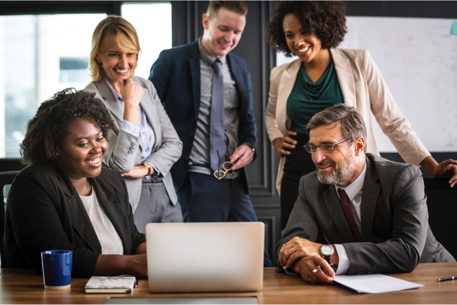 Group of diverse coworkers gathered around a laptop